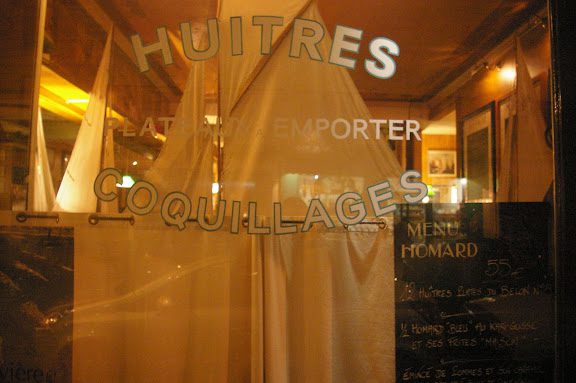 A window with the words huitres, couliages and porter written in it.