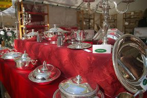 A table with many silver plates and silverware on it