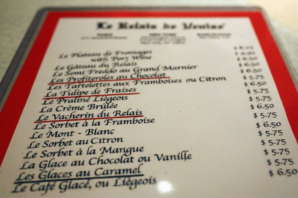 A menu of french cuisine on the table.