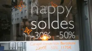 A store window with the words happy soldes in orange.