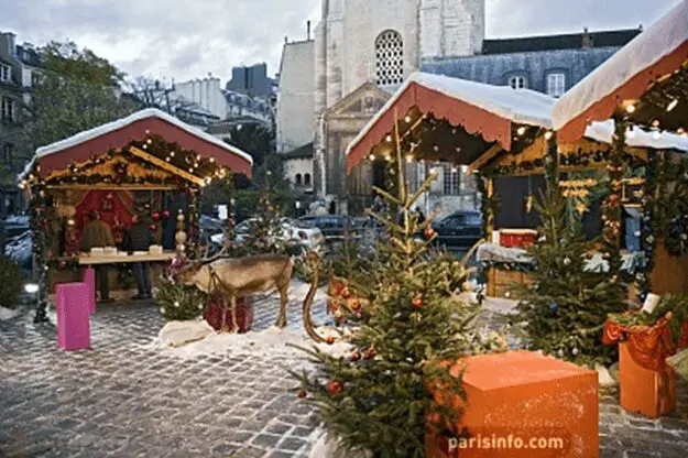 A christmas market with trees and decorations on the ground.
