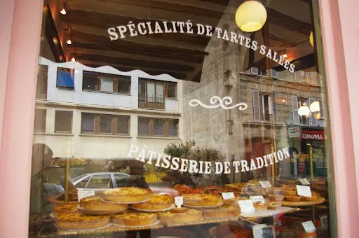 A bakery window with pastries on display in it.