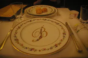 A table with two plates and one is decorated with the letter b.