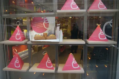 A window display of pastries in the shape of triangles.