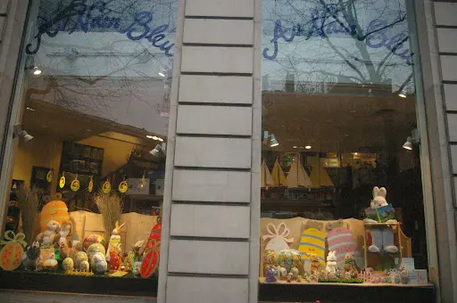 A store front with many bags of goods in the window.
