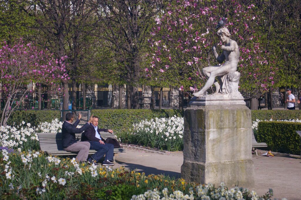 Three people sitting on a bench in the park