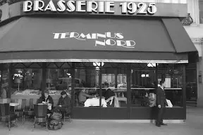 A black and white photo of people outside a restaurant.