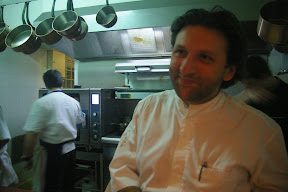 A man in white shirt sitting at counter.