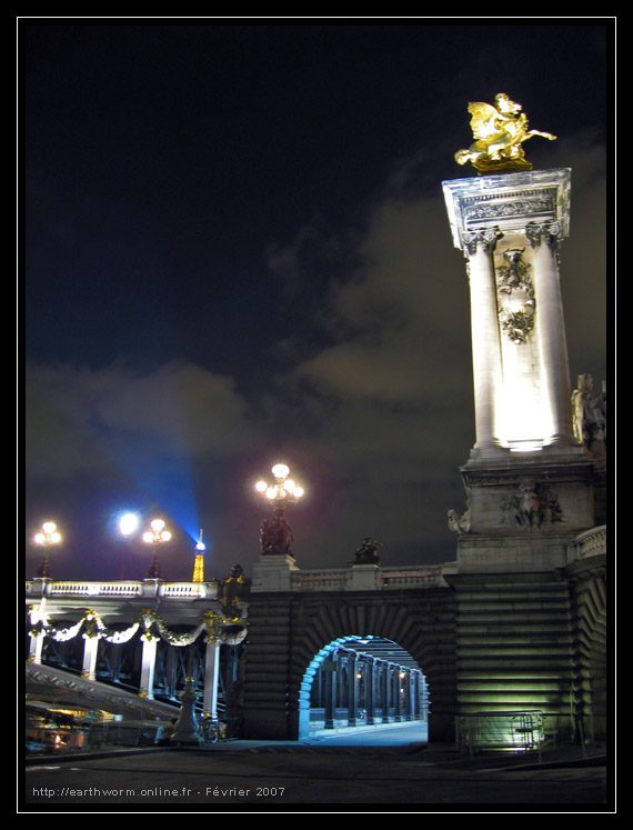 A night time view of the bridge and statue.