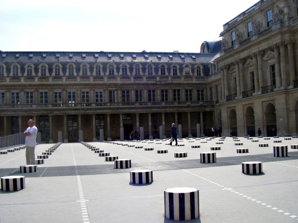 A large courtyard with many black and white striped columns.