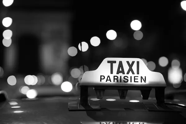 A taxi sign on the back of a car.