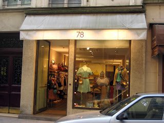 A store front with several mannequins and clothing on display.