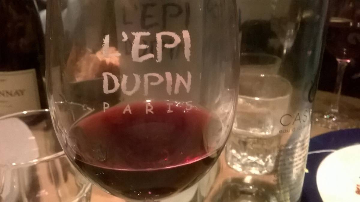 A glass of wine with the name " epi dupin paris ".