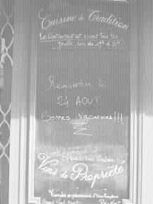 A black and white photo of a restaurant window.