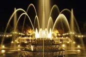 A fountain with many lights and people in it