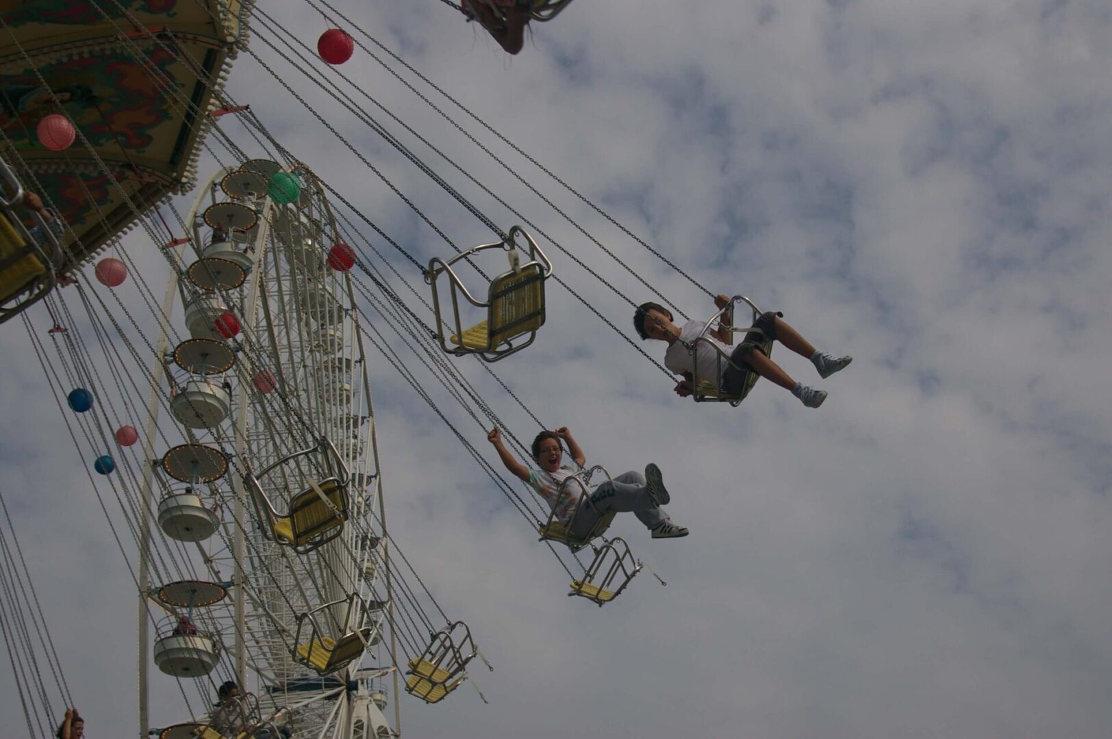 A group of people riding on the side of a ferris wheel.