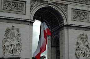 A flag hanging from the arch of an archway.