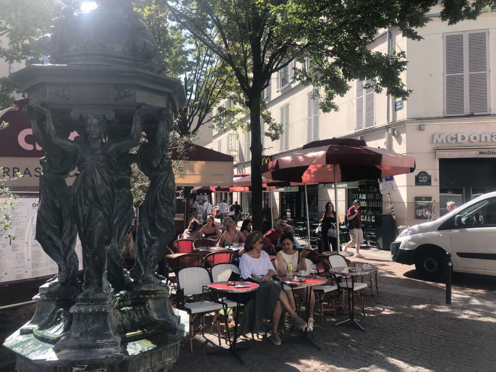 A group of people sitting at tables outside